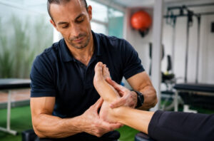 Fisioterapeuta realizando terapia manual para tratamento de esporão de calcâneo em clínica especializada