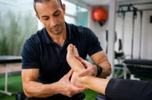 Fisioterapeuta realizando terapia manual para tratamento de esporão de calcâneo em clínica especializada